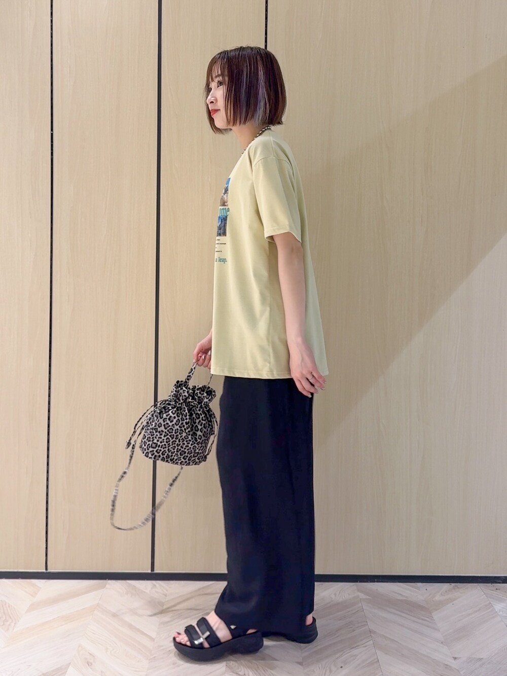 イエロー系のTシャツ/カットソー、ブラック系のサンダル、ベージュ系のショルダーバッグを着用したレディースの夏コーディネートの10枚目の写真