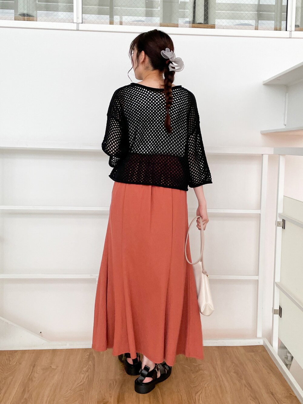 ブラック系のその他トップス、オレンジ系のスカート、ブラック系のサンダルを着用したレディースの春コーディネートの3枚目の写真