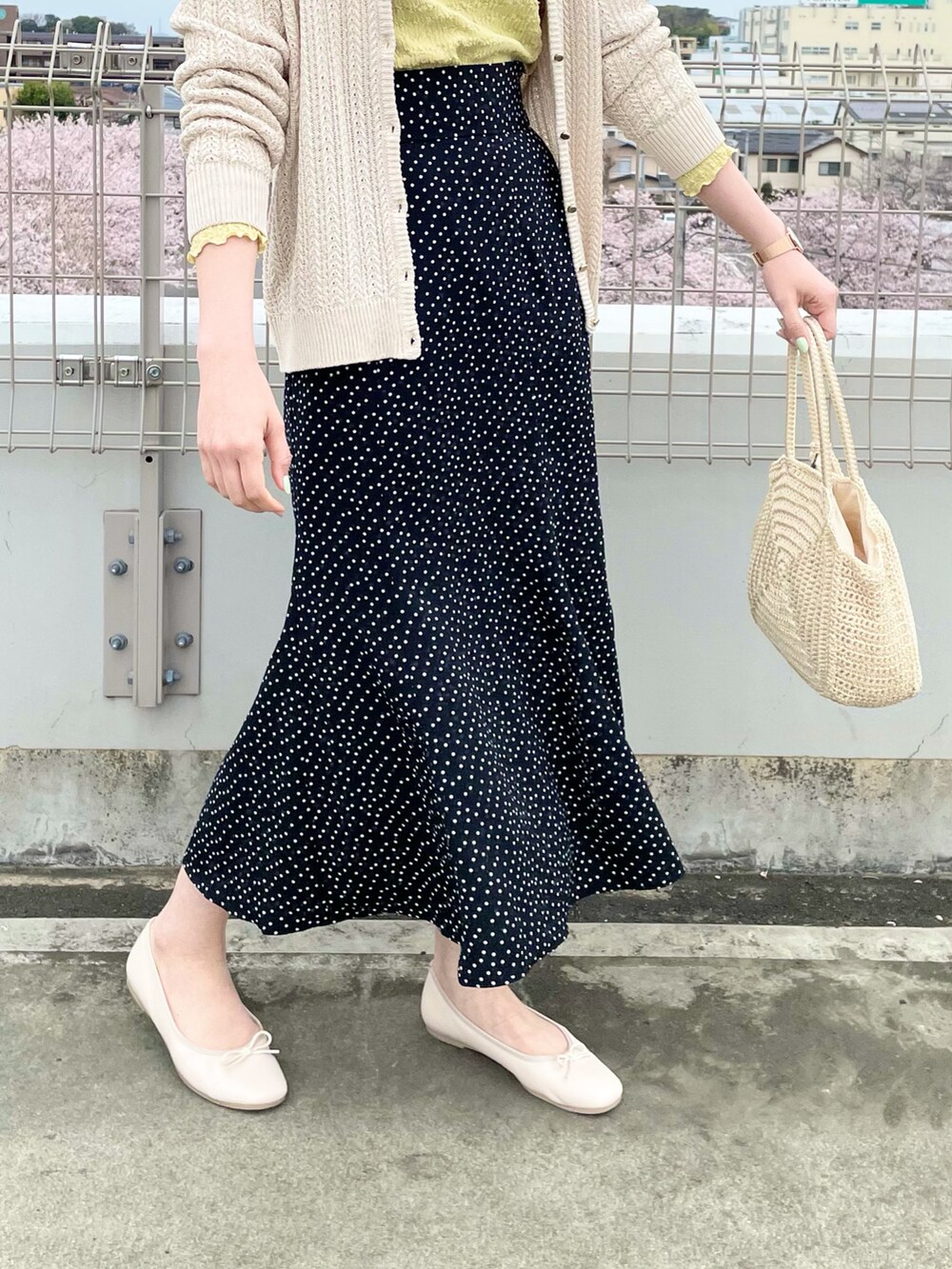 ホワイト系のカーディガン/ボレロ、イエロー系のTシャツ/カットソー、ブラック系のスカートを着用したレディースの春コーディネートの4枚目の写真