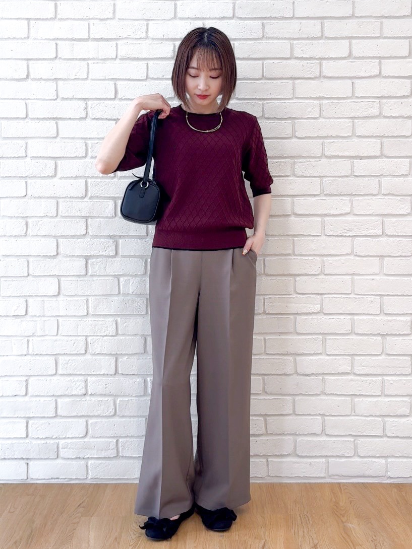 レッド系のニット/セーター、ブラウン系のその他パンツ、ブラック系のショルダーバッグを着用したレディースの夏コーディネートの5枚目の写真