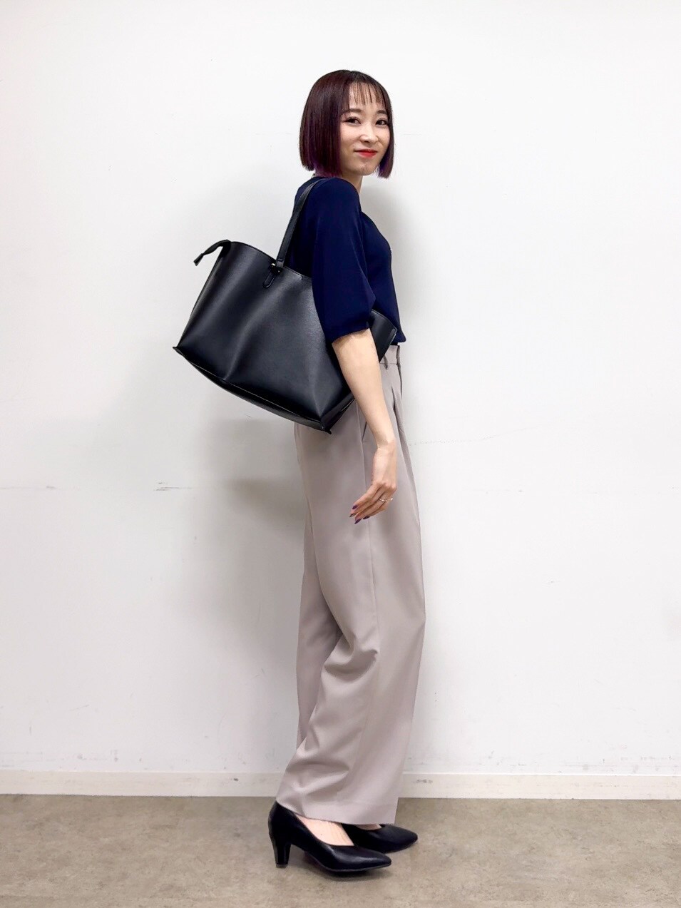 ブルー系のニット/セーター、ベージュ系のその他パンツ、ブラック系のパンプスを着用したレディースの春コーディネートの4枚目の写真