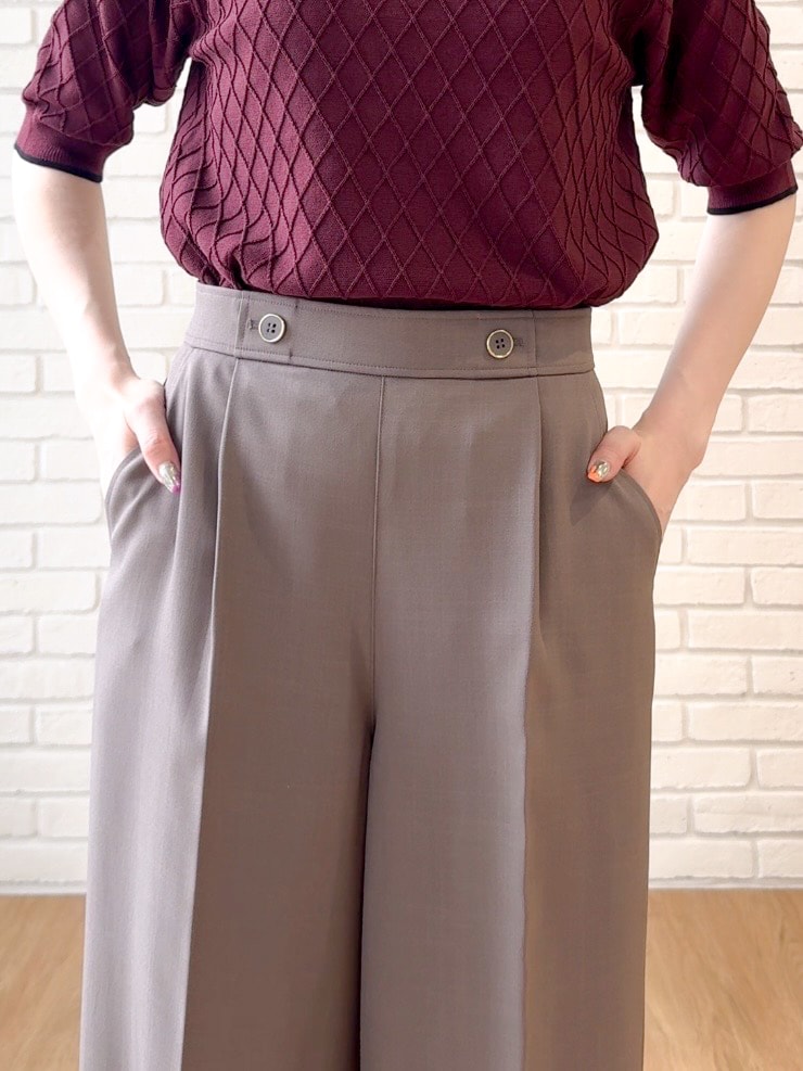 レッド系のニット/セーター、ブラウン系のその他パンツ、ブラック系のショルダーバッグを着用したレディースの夏コーディネートの6枚目の写真
