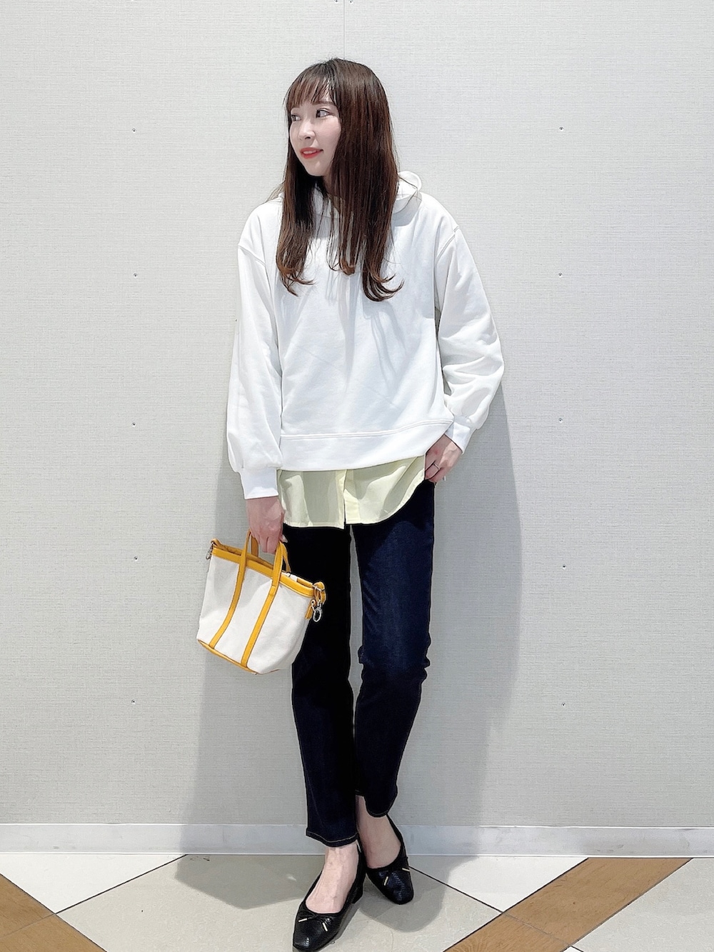 ホワイト系のパーカー、イエロー系のシャツ/ブラウス、ブルー系のデニムパンツを着用したレディースの春コーディネートの2枚目の写真