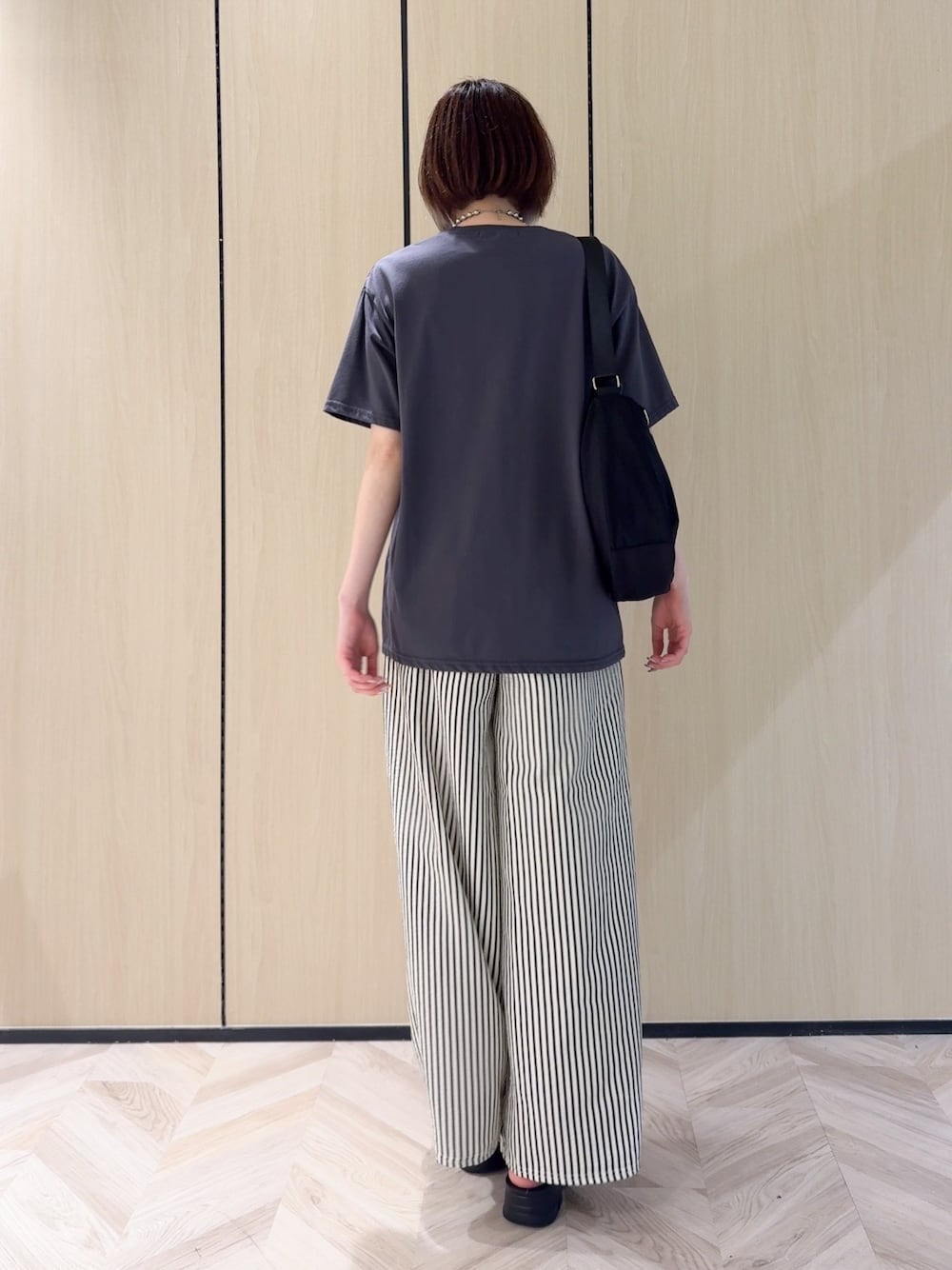 グレー系のTシャツ/カットソー、ホワイト系のその他パンツ、ブラック系のサンダルを着用したレディースの夏コーディネートの9枚目の写真