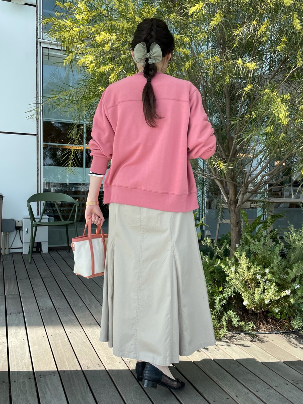 ピンク系のカーディガン/ボレロ、ブラック系のTシャツ/カットソー、ベージュ系のスカートを着用したレディースの春コーディネートの3枚目の写真