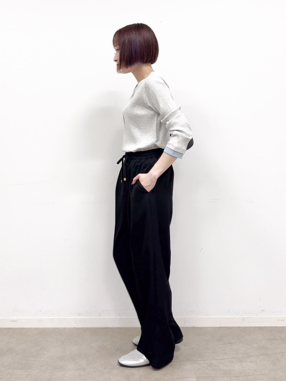 グレー系のTシャツ/カットソー、ブラック系のその他パンツ、シルバー系のパンプスを着用したレディースの秋コーディネートの4枚目の写真