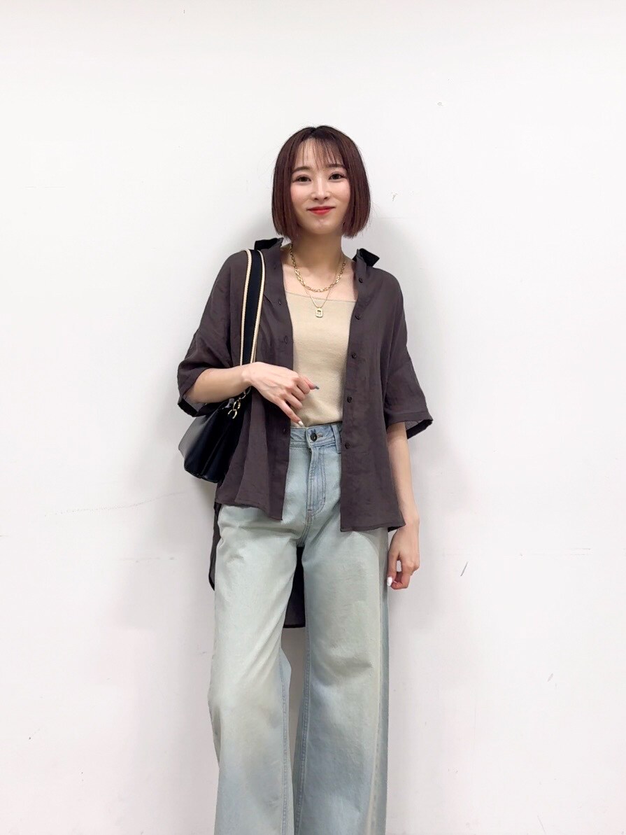 グレー系のシャツ/ブラウス、ゴールド系のタンクトップ、ブルー系のデニムパンツを着用したレディースの春コーディネートの5枚目の写真