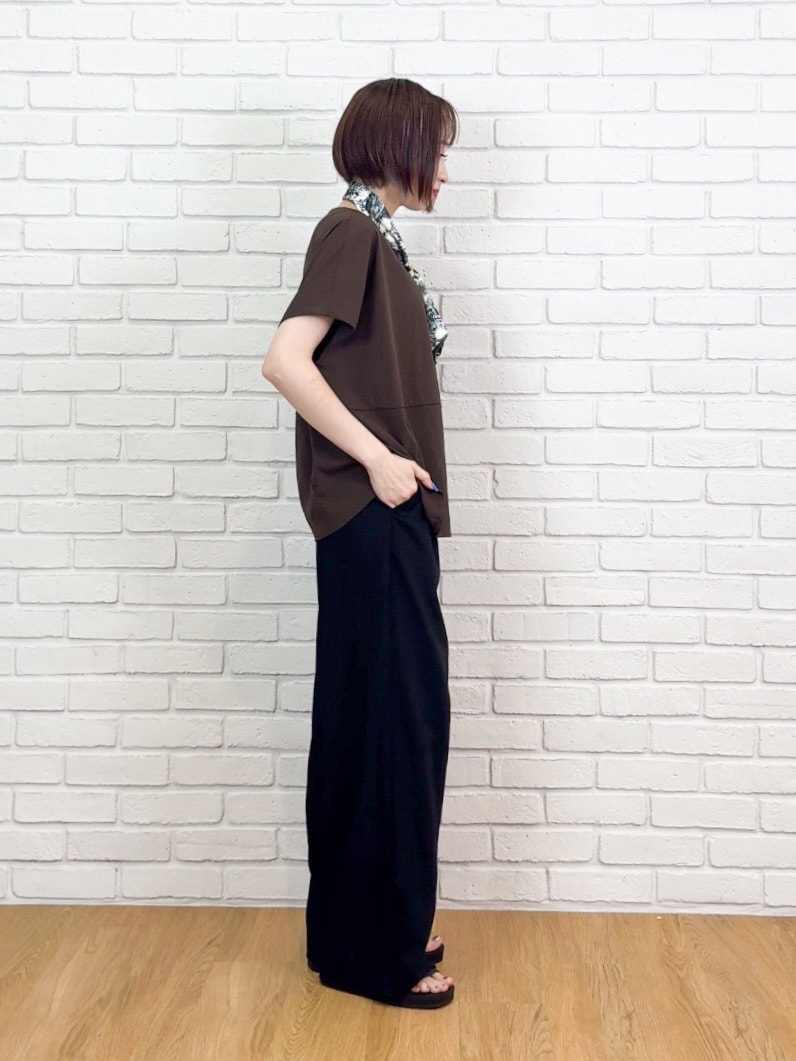 ブラウン系のTシャツ/カットソー、ブラック系のサンダル、ベージュ系のチャームを着用したレディースの夏コーディネートの2枚目の写真