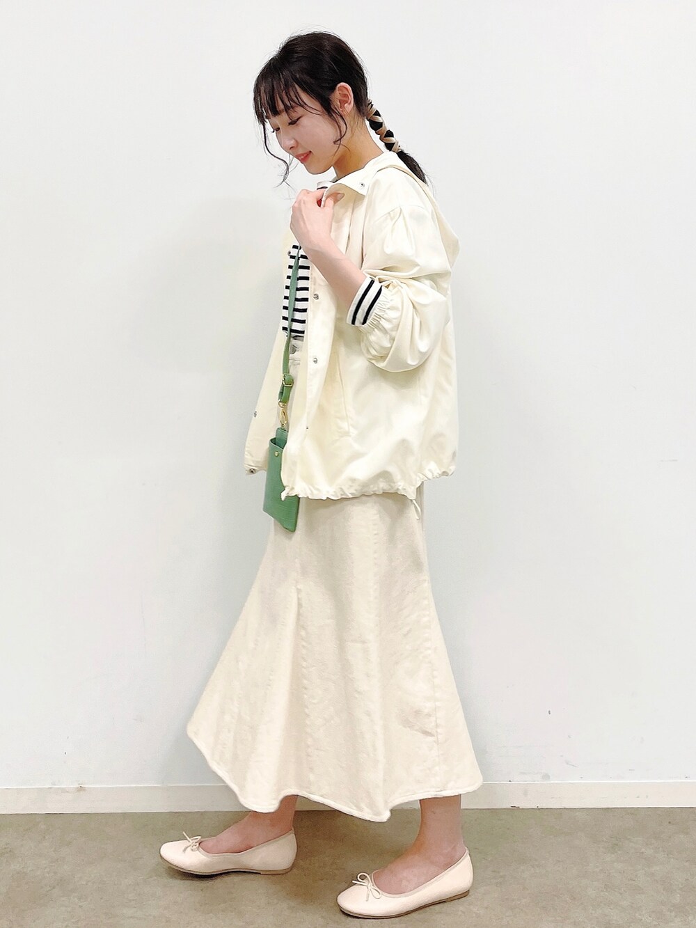 ホワイト系のブルゾン、ブラック系のTシャツ/カットソー、ホワイト系のデニムスカートを着用したレディースの春コーディネートの2枚目の写真