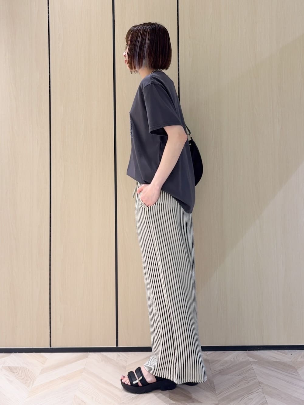 グレー系のTシャツ/カットソー、ホワイト系のその他パンツ、ブラック系のサンダルを着用したレディースの夏コーディネートの4枚目の写真
