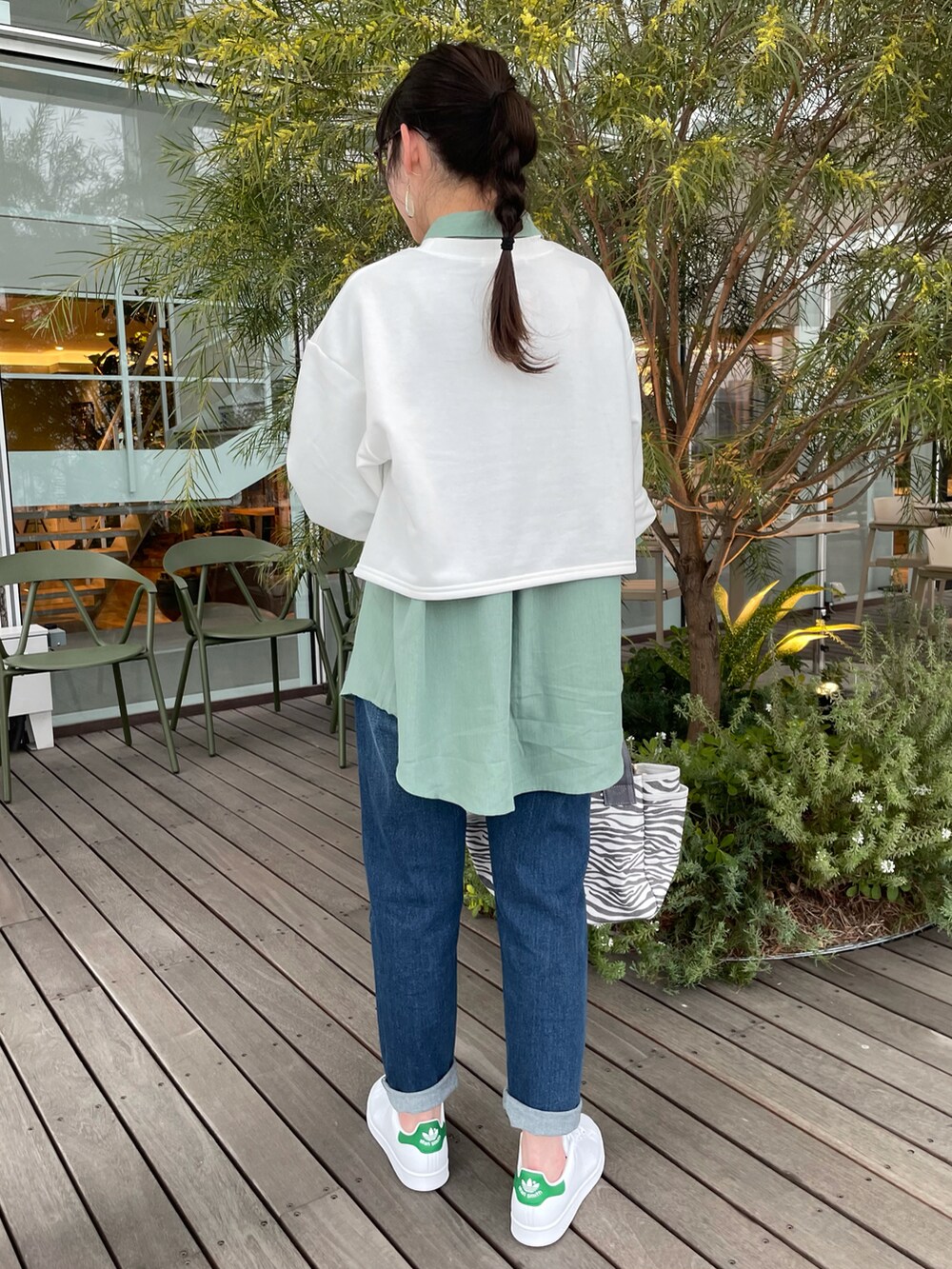 ホワイト系のスウェット、グリーン系のシャツ/ブラウス、ブルー系のデニムパンツを着用したレディースの春コーディネートの3枚目の写真