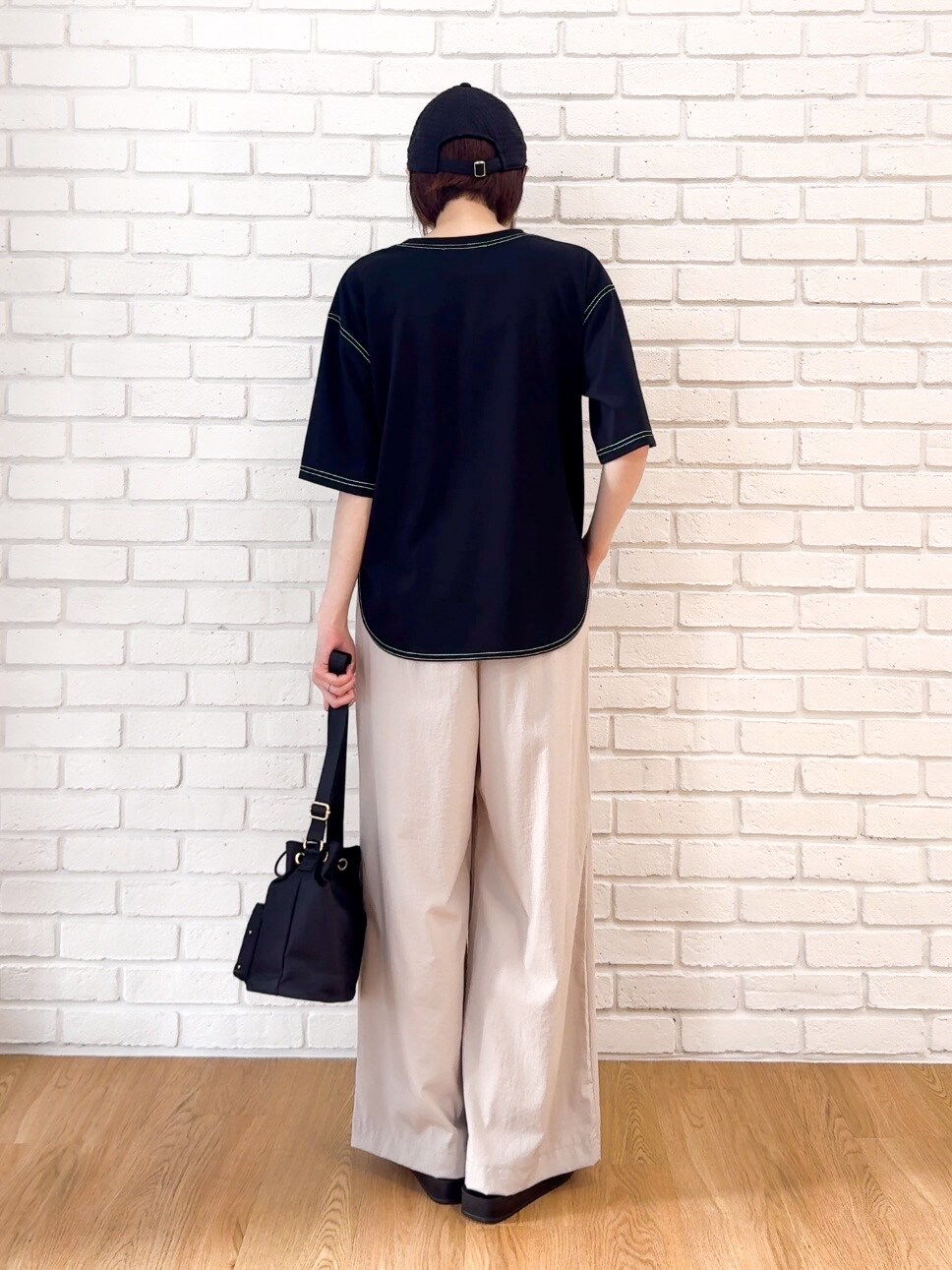 ブラック系のTシャツ/カットソー、ベージュ系のその他パンツ、ブラック系のサンダルを着用したレディースの夏コーディネートの3枚目の写真