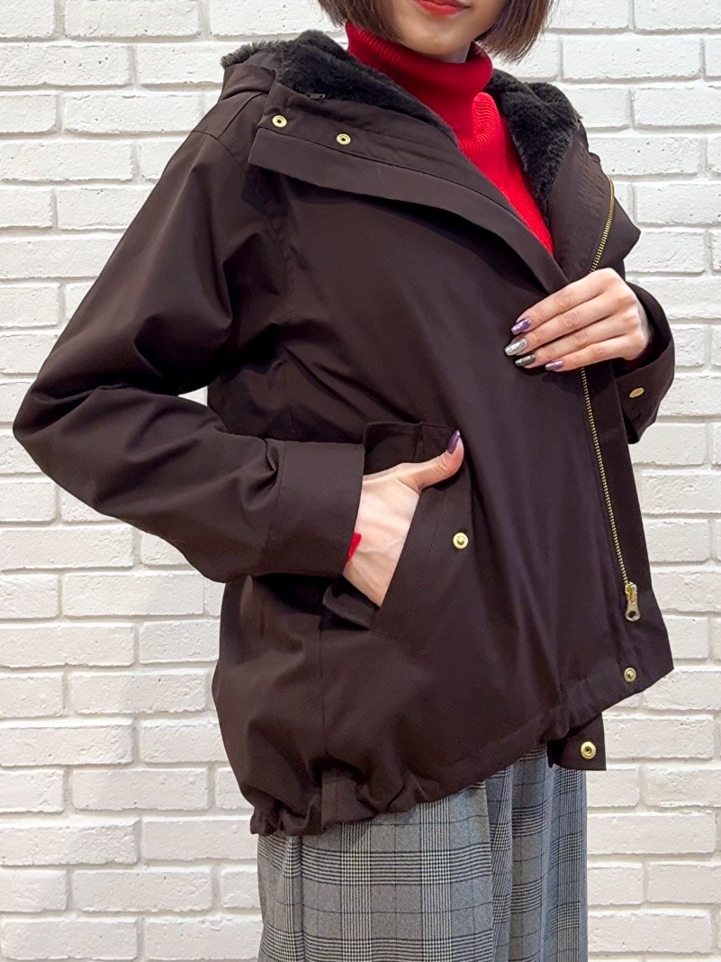 レッド系のニット/セーター、グレー系のその他パンツ、ブラウン系のブーツを着用したレディースの秋コーディネートの9枚目の写真