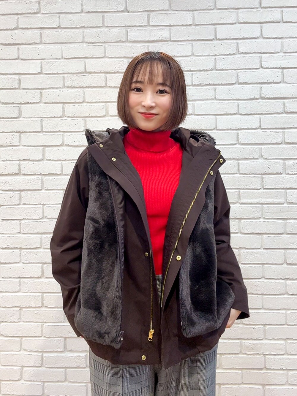 レッド系のニット/セーター、グレー系のその他パンツ、ブラウン系のブーツを着用したレディースの秋コーディネートの7枚目の写真
