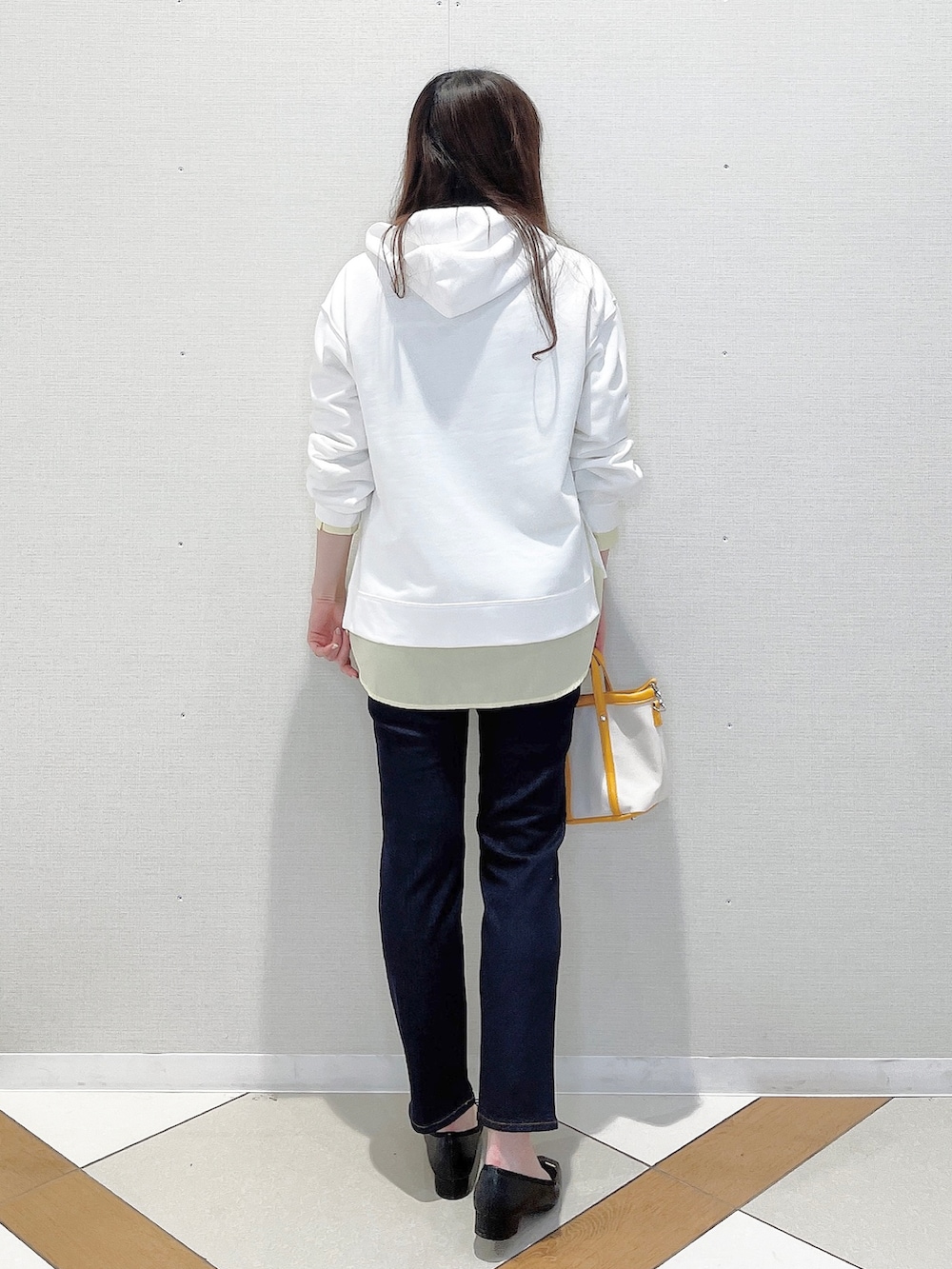 ホワイト系のパーカー、イエロー系のシャツ/ブラウス、ブルー系のデニムパンツを着用したレディースの春コーディネートの3枚目の写真