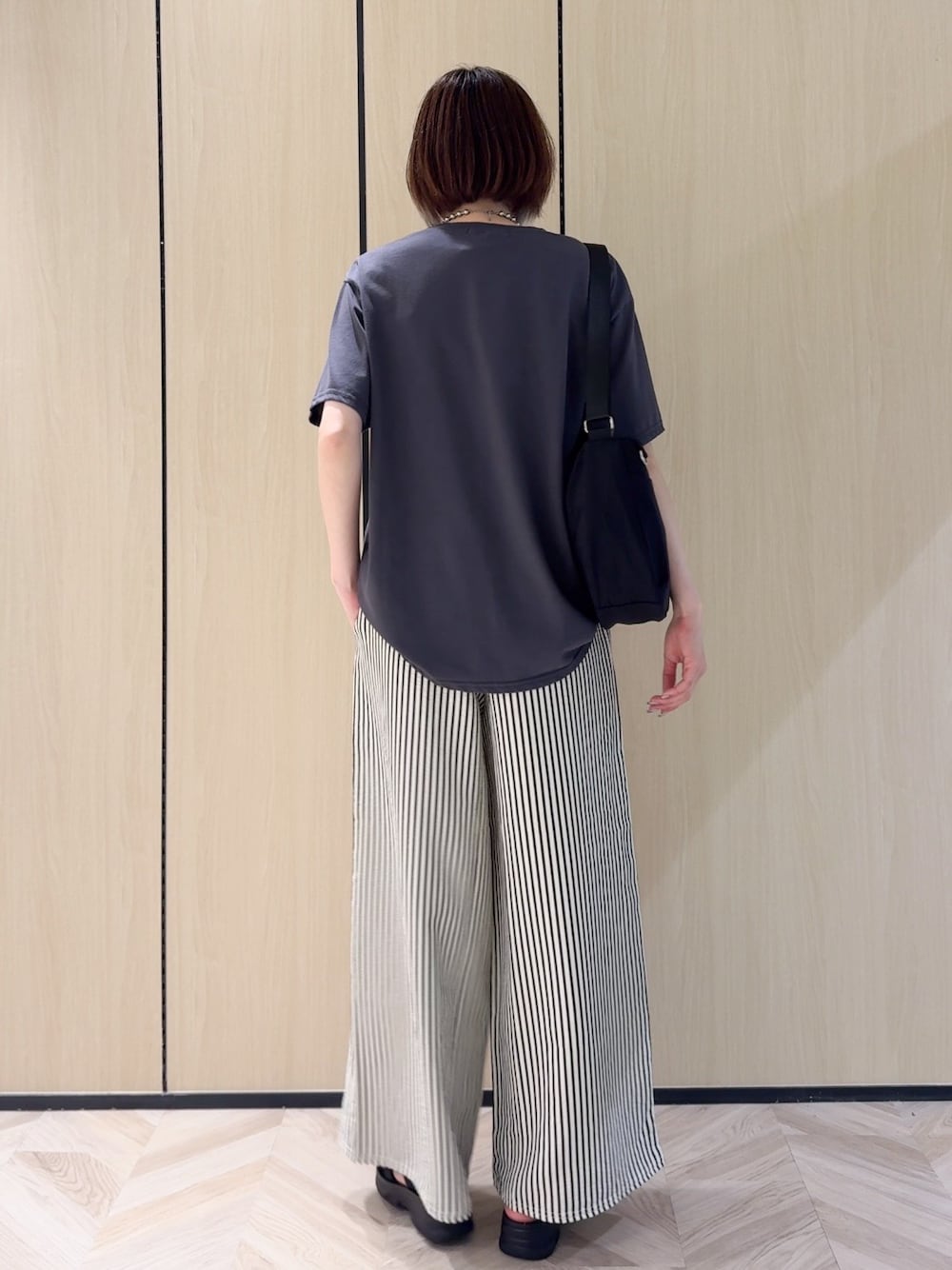 グレー系のTシャツ/カットソー、ホワイト系のその他パンツ、ブラック系のサンダルを着用したレディースの夏コーディネートの3枚目の写真