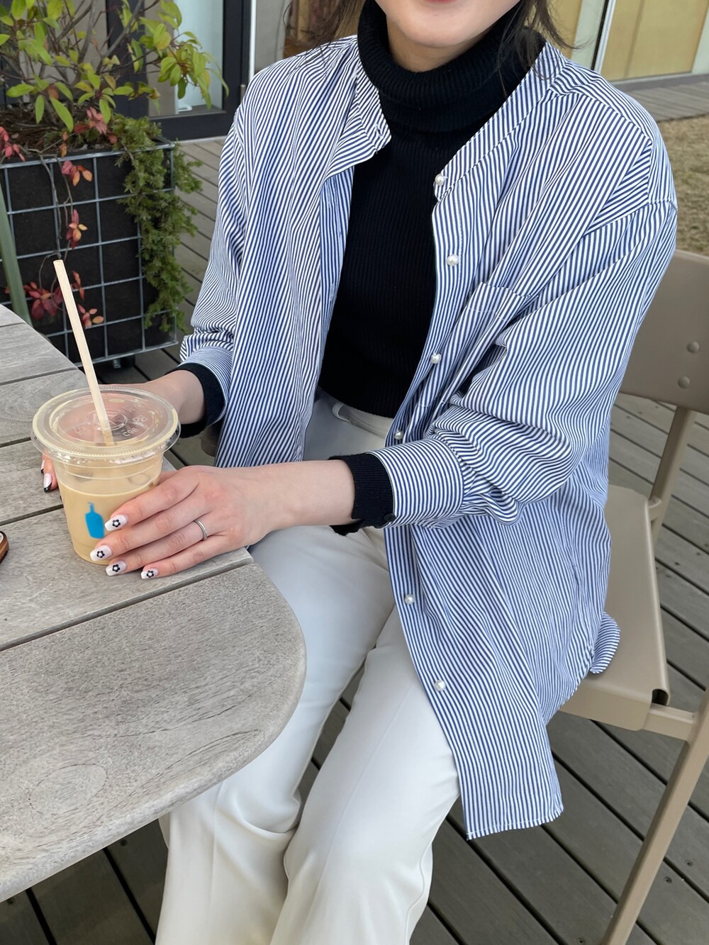 ブルー系のシャツ/ブラウス、ブラック系のニット/セーターを着用したレディースの春コーディネートの3枚目の写真