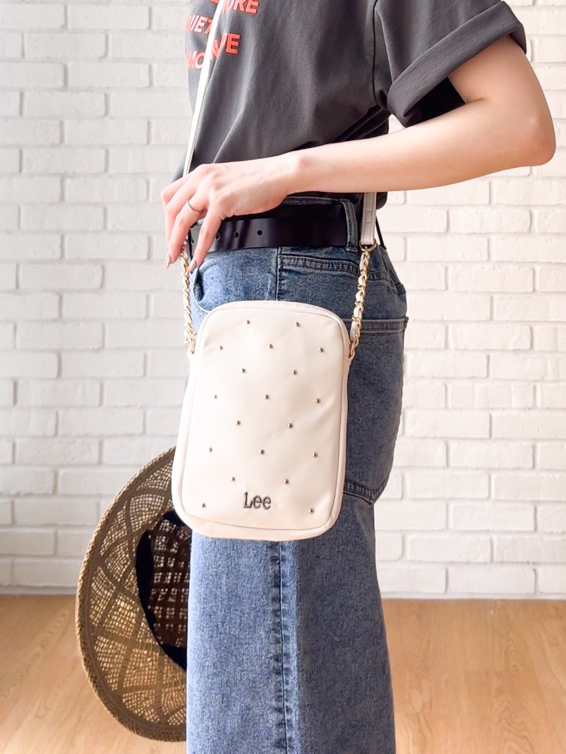グレー系のTシャツ/カットソー、ブルー系のデニムパンツ、ホワイト系のショルダーバッグを着用したレディースの夏コーディネートの5枚目の写真