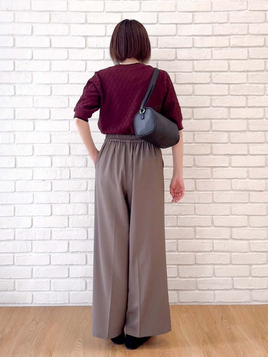 レッド系のニット/セーター、ブラウン系のその他パンツ、ブラック系のショルダーバッグを着用したレディースの夏コーディネートの3枚目の写真