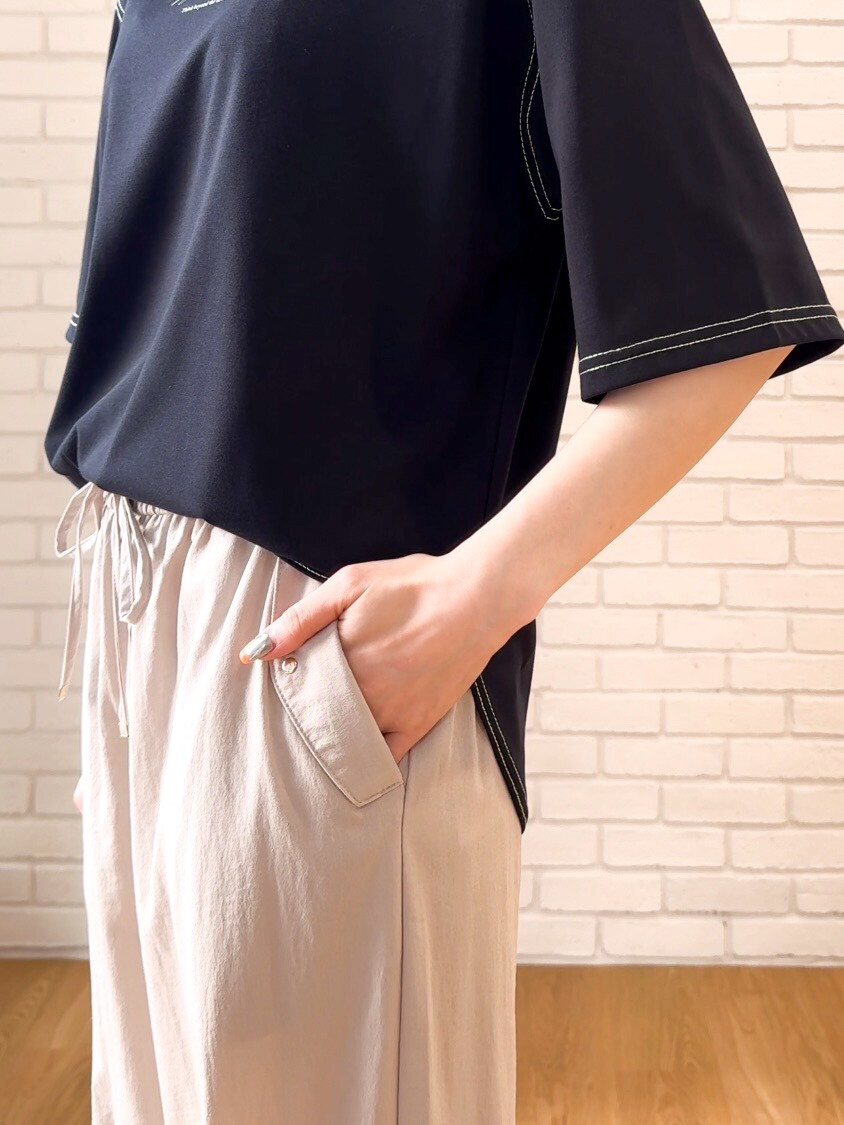 ブラック系のTシャツ/カットソー、ベージュ系のその他パンツ、ブラック系のサンダルを着用したレディースの夏コーディネートの6枚目の写真