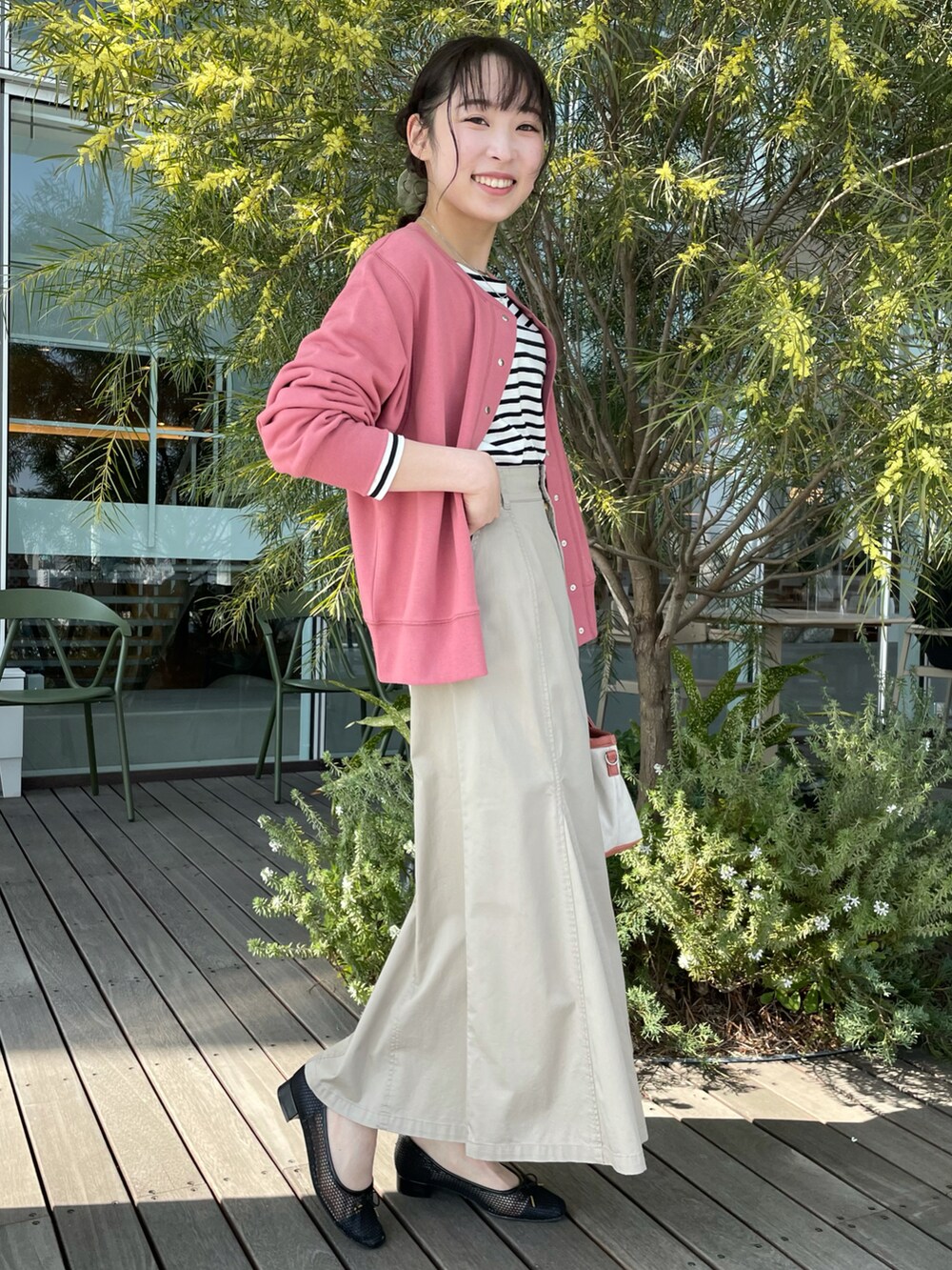 ピンク系のカーディガン/ボレロ、ブラック系のTシャツ/カットソー、ベージュ系のスカートを着用したレディースの春コーディネートの2枚目の写真