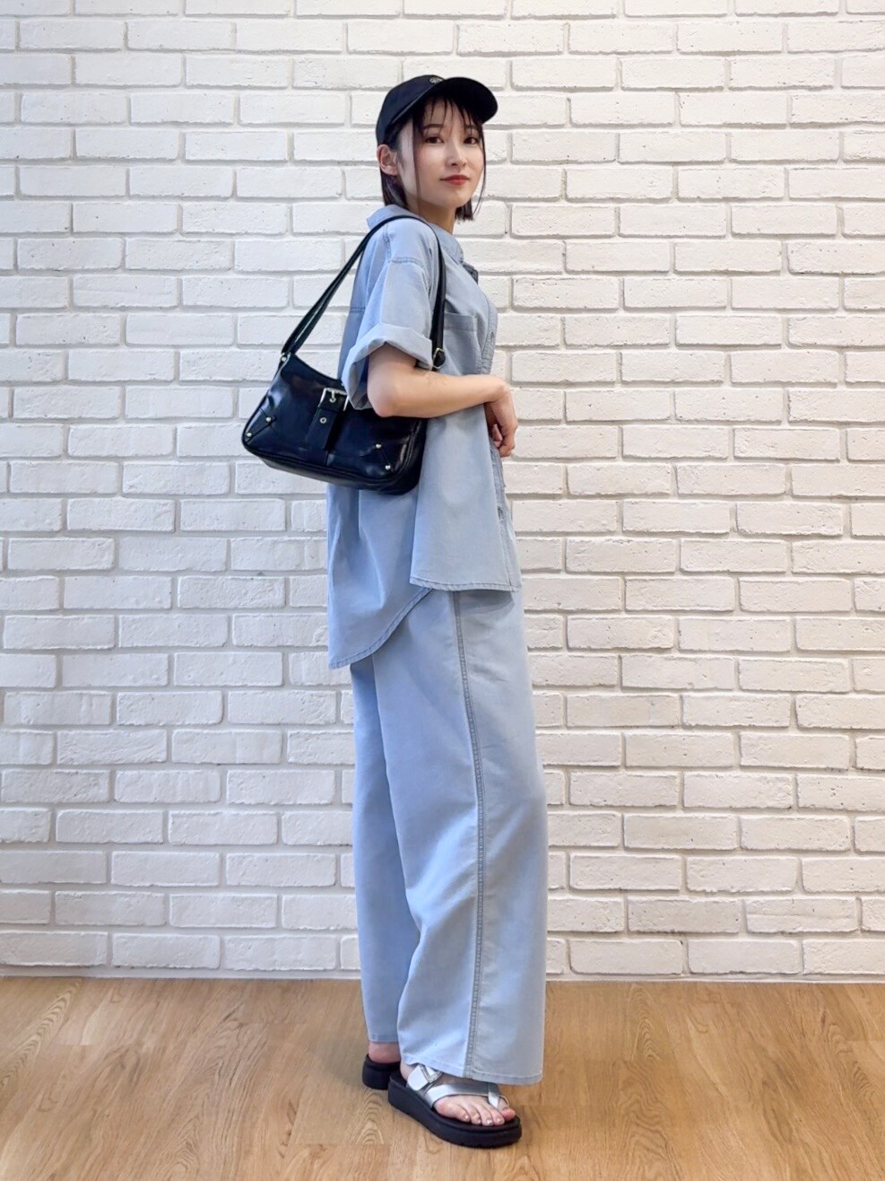 ブルー系のシャツ/ブラウス、ブラック系のタンクトップ、ブルー系のデニムパンツを着用したレディースの夏コーディネートの2枚目の写真