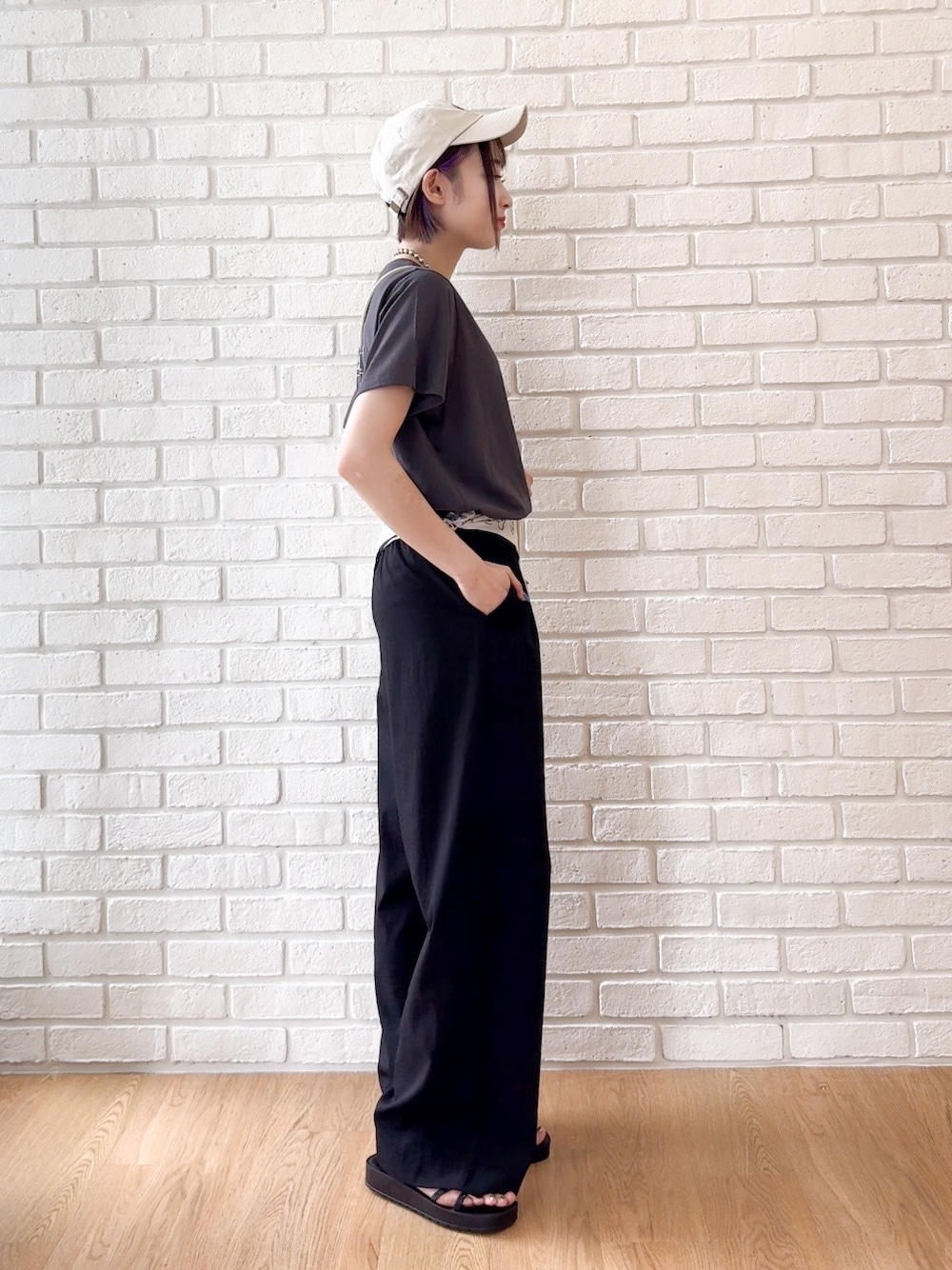 グレー系のTシャツ/カットソー、ブラック系のサンダル、ベージュ系のキャップを着用したレディースの夏コーディネートの2枚目の写真