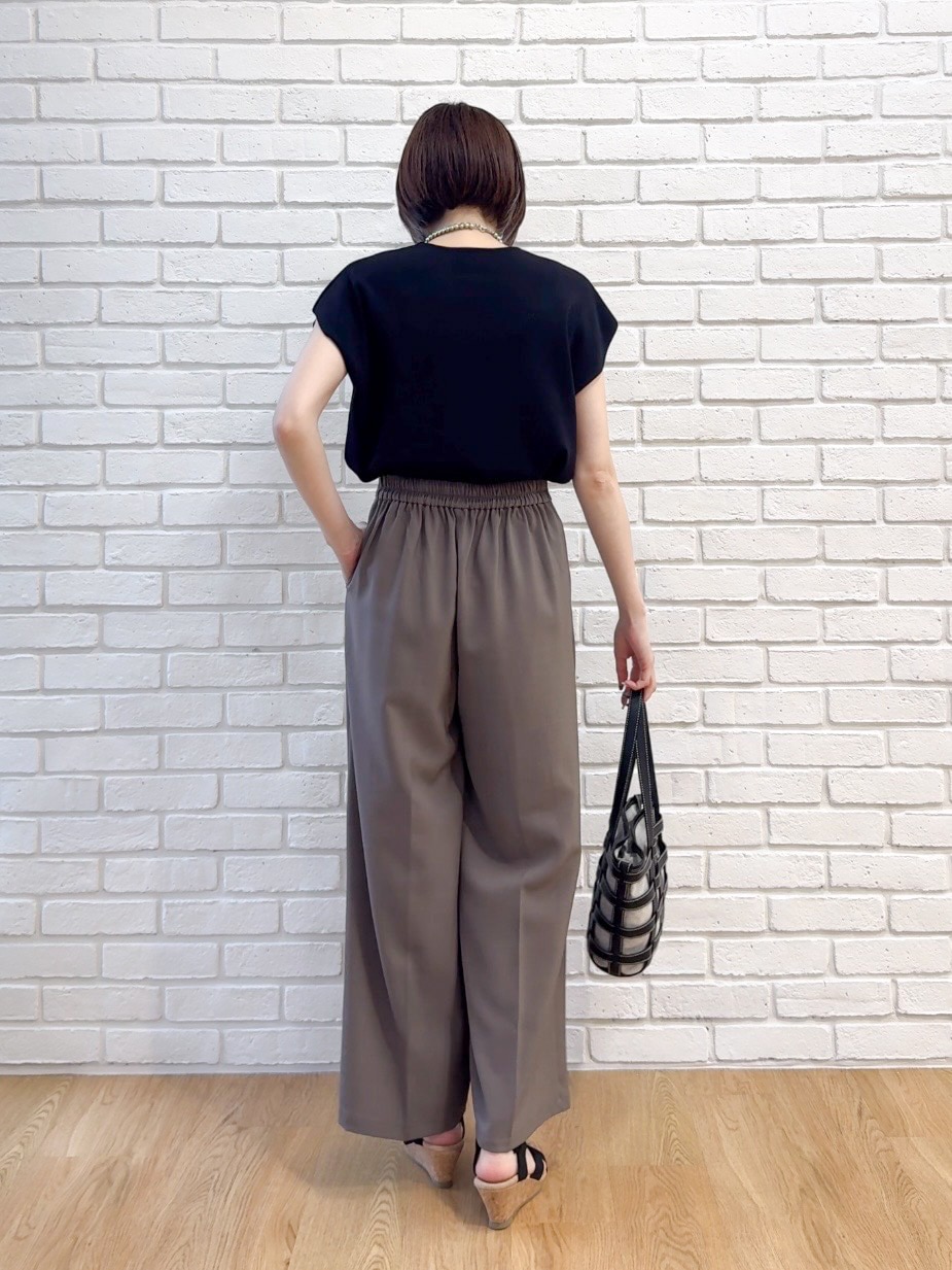 ブラック系のニット/セーター、ブラウン系のその他パンツ、ブラック系のサンダルを着用したレディースの夏コーディネートの3枚目の写真