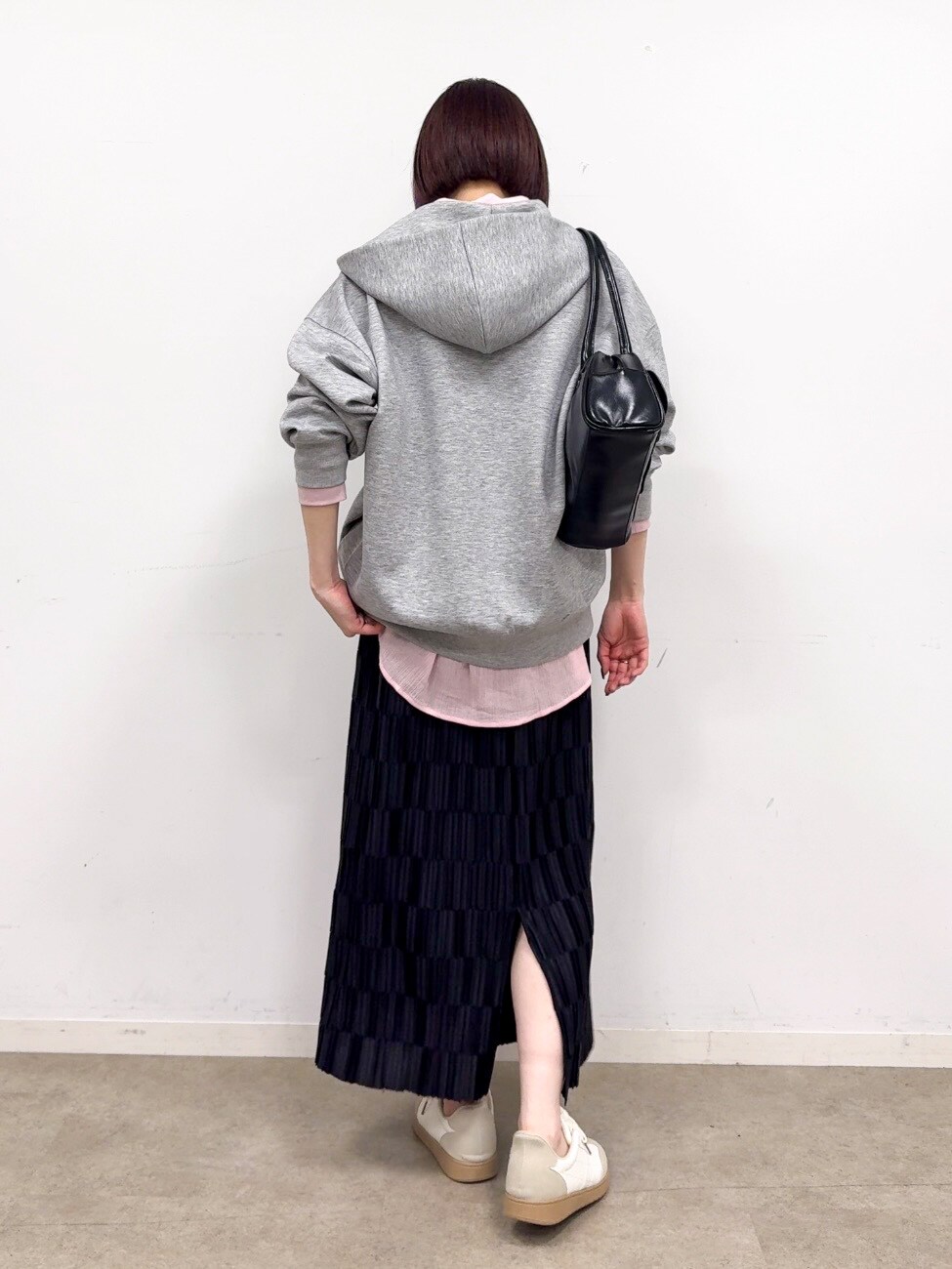 グレー系のパーカー、ピンク系のシャツ/ブラウス、ブラック系のスカートを着用したレディースの春コーディネートの3枚目の写真