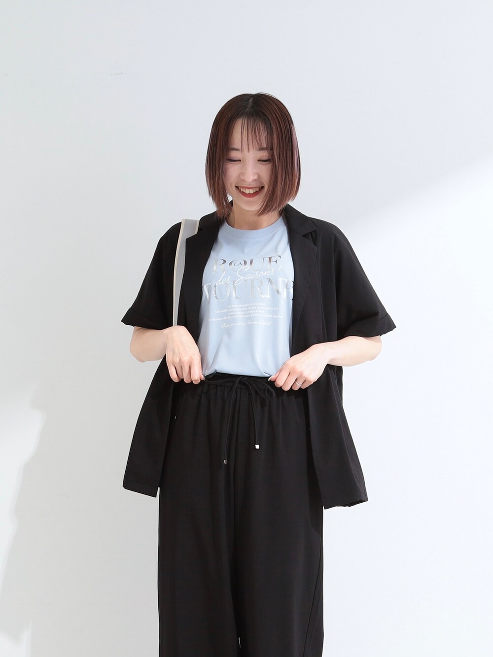 ブラック系のテーラードジャケット、ブルー系のTシャツ/カットソー、ブラック系のその他パンツを着用したレディースの夏コーディネートの5枚目の写真