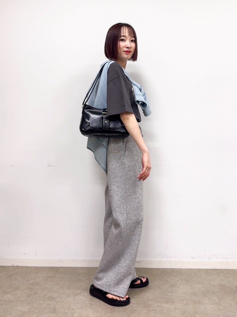ブルー系のシャツ/ブラウス、グレー系のその他パンツ、ブラック系のショルダーバッグを着用したレディースの春コーディネートの2枚目の写真