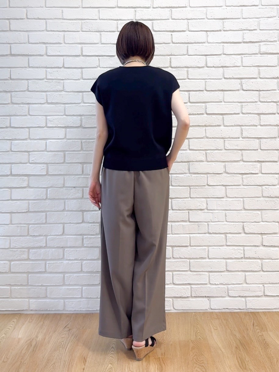 ブラック系のニット/セーター、ブラウン系のその他パンツ、ブラック系のサンダルを着用したレディースの夏コーディネートの7枚目の写真