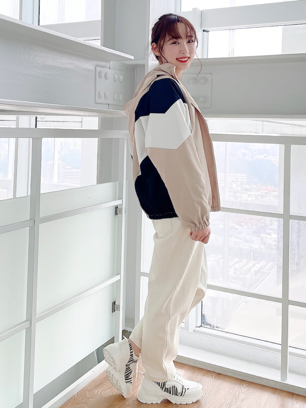 ベージュ系のブルゾン、ホワイト系のサロペット/オーバーオール、イエロー系のニット/セーターを着用したレディースの春コーディネートの2枚目の写真