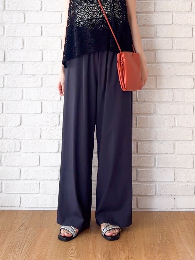 ホワイト系のニット/セーター、グレー系のその他パンツ、ブラック系のサンダルを着用したレディースの夏コーディネートの8枚目の写真