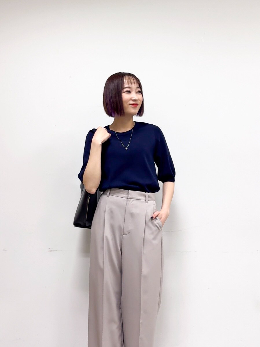 ブルー系のニット/セーター、ベージュ系のその他パンツ、ブラック系のパンプスを着用したレディースの春コーディネートの6枚目の写真