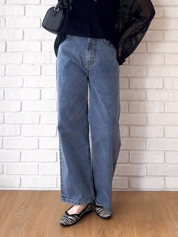 ブラック系のタンクトップ、ブルー系のデニムパンツ、ブラック系のパンプスを着用したレディースの夏コーディネートの5枚目の写真