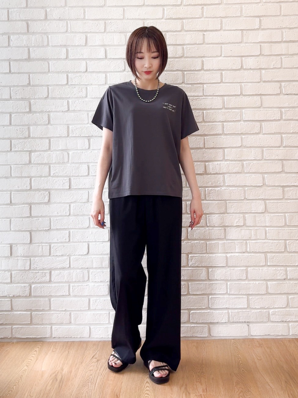 グレー系のTシャツ/カットソー、ブラック系のサンダル、ベージュ系のキャップを着用したレディースの夏コーディネートの4枚目の写真