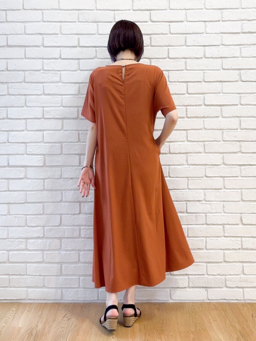 ブラック系のシャツ/ブラウス、オレンジ系のワンピース、ブラック系のサンダルを着用したレディースの夏コーディネートの9枚目の写真