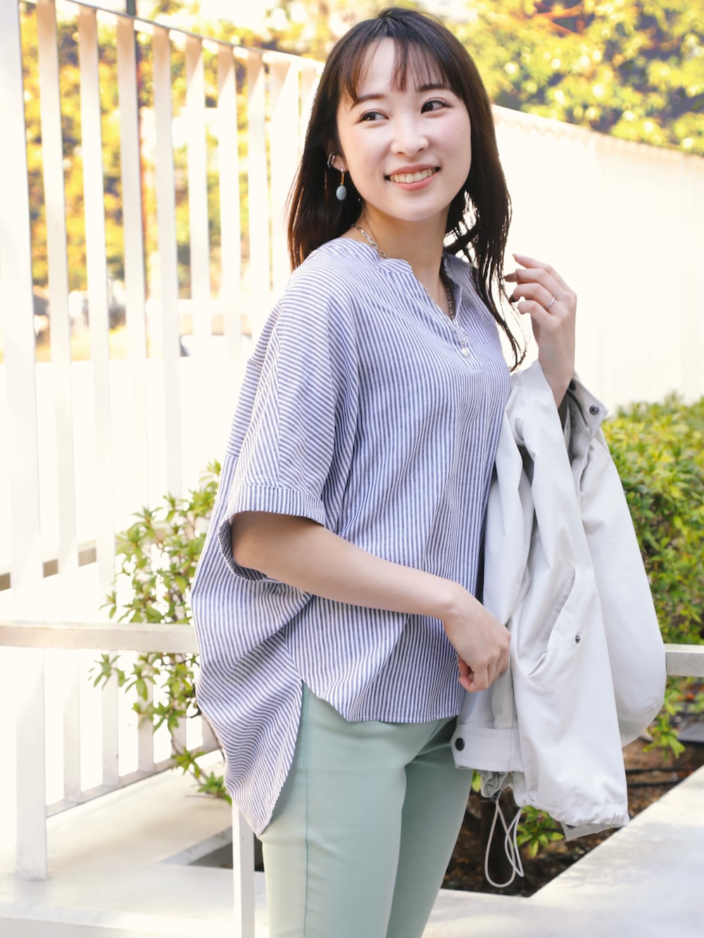 ホワイト系のブルゾン、グリーン系のその他パンツ、グレー系のスニーカーを着用したレディースの春コーディネートの2枚目の写真