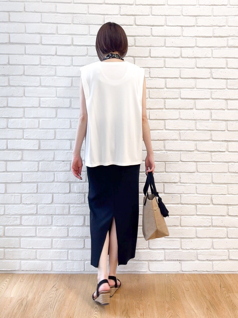 ホワイト系のTシャツ/カットソー、ブラック系のスカート、ブラック系のサンダルを着用したレディースの夏コーディネートの3枚目の写真