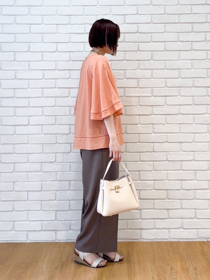 オレンジ系のシャツ/ブラウス、ブラウン系のその他パンツ、ホワイト系のサンダルを着用したレディースの夏コーディネートの2枚目の写真