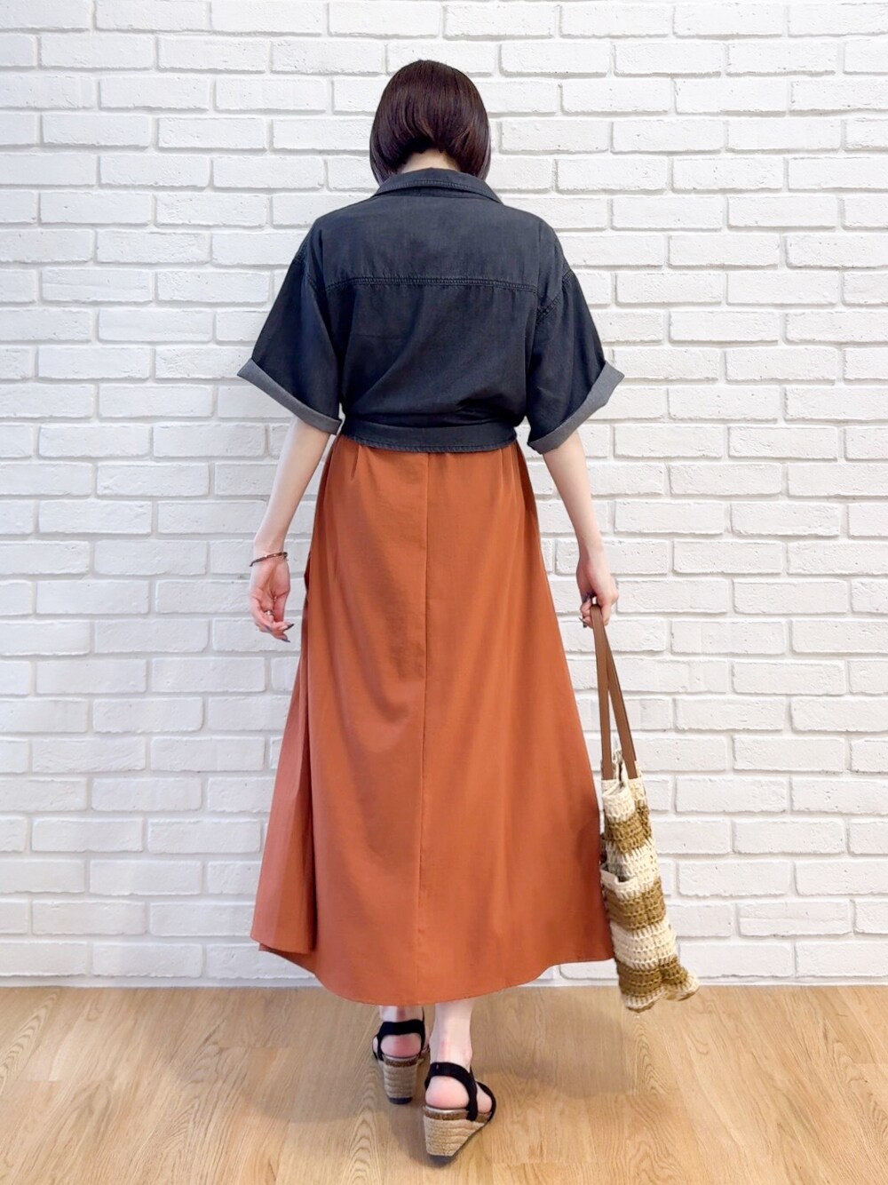 ブラック系のシャツ/ブラウス、オレンジ系のワンピース、ブラック系のサンダルを着用したレディースの夏コーディネートの3枚目の写真
