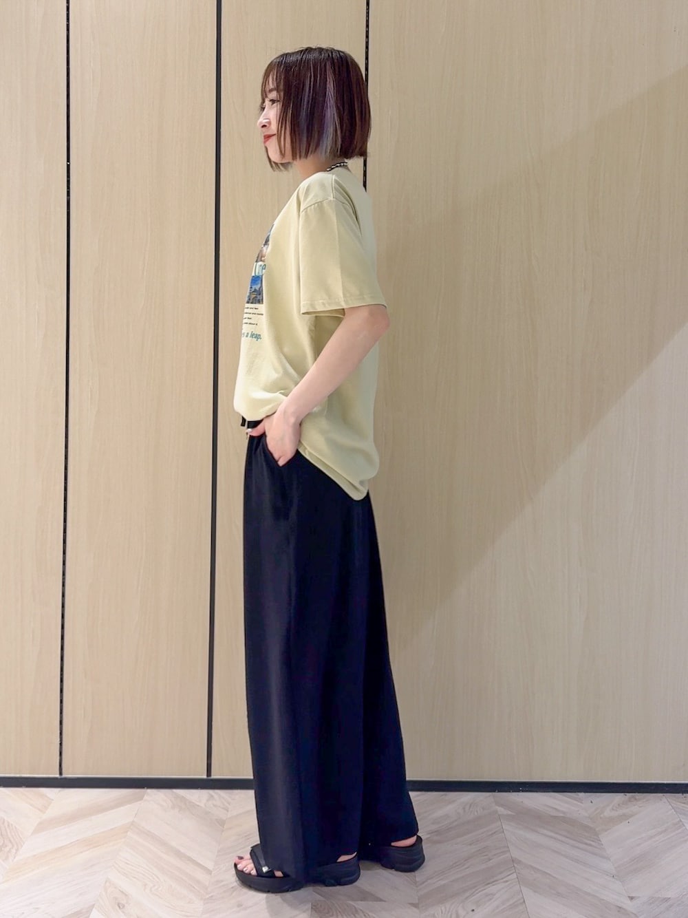 イエロー系のTシャツ/カットソー、ブラック系のサンダル、ベージュ系のショルダーバッグを着用したレディースの夏コーディネートの4枚目の写真