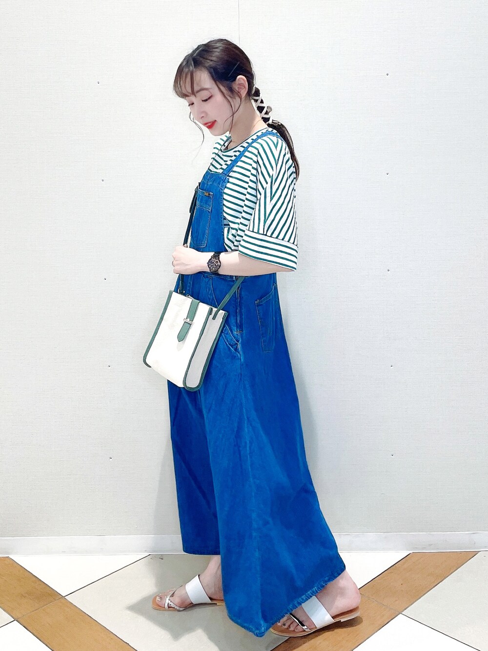 グリーン系のTシャツ/カットソー、ブルー系のサロペット/オーバーオール、ベージュ系のサンダルを着用したレディースの夏コーディネートの2枚目の写真