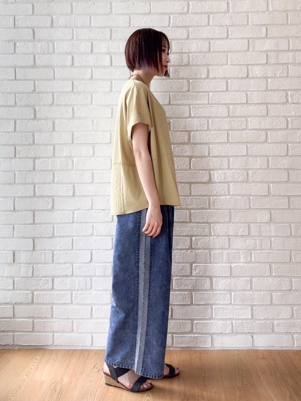 イエロー系のTシャツ/カットソー、ブルー系のデニムパンツ、ブラック系のサンダルを着用したレディースの夏コーディネートの8枚目の写真