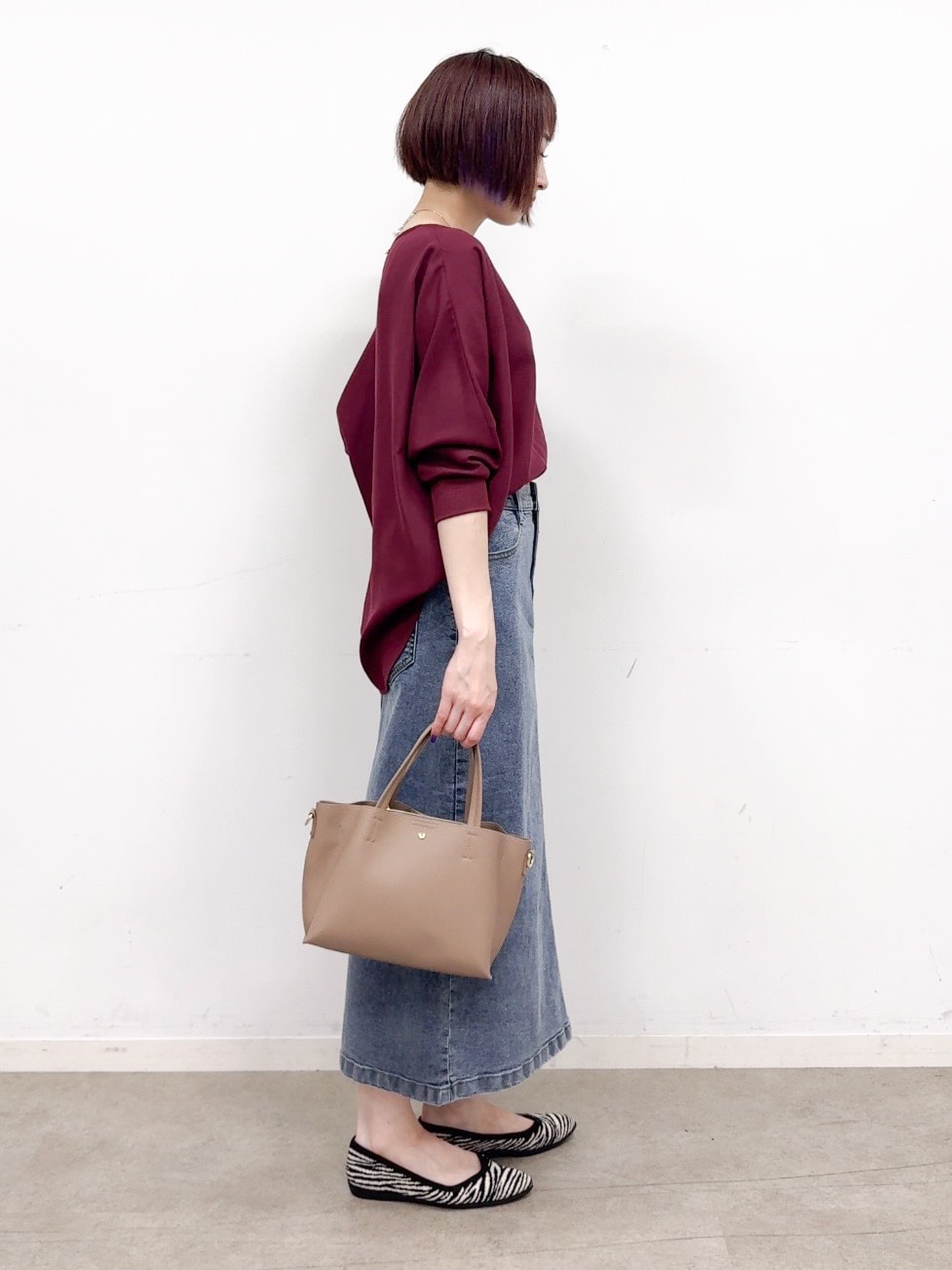 レッド系のシャツ/ブラウス、ブルー系のデニムスカート、ブラック系のパンプスを着用したレディースの秋コーディネートの2枚目の写真