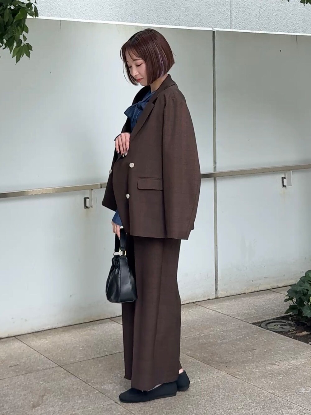 ブラウン系のその他パンツ、ブラック系のその他シューズ、ブラック系のショルダーバッグを着用したレディースの秋コーディネートの2枚目の写真