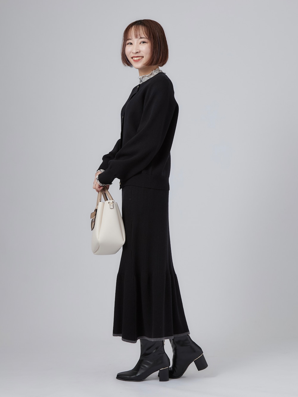 ブラック系のカーディガン/ボレロ、グレー系のTシャツ/カットソー、ブラック系のブーツを着用したレディースの秋コーディネートの4枚目の写真