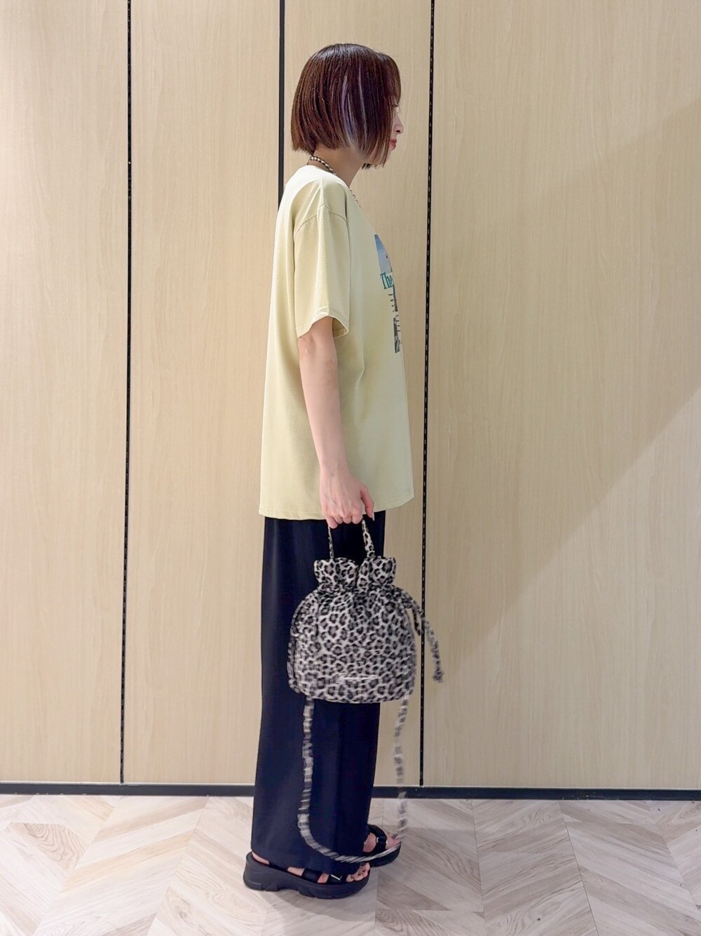 イエロー系のTシャツ/カットソー、ブラック系のサンダル、ベージュ系のショルダーバッグを着用したレディースの夏コーディネートの8枚目の写真