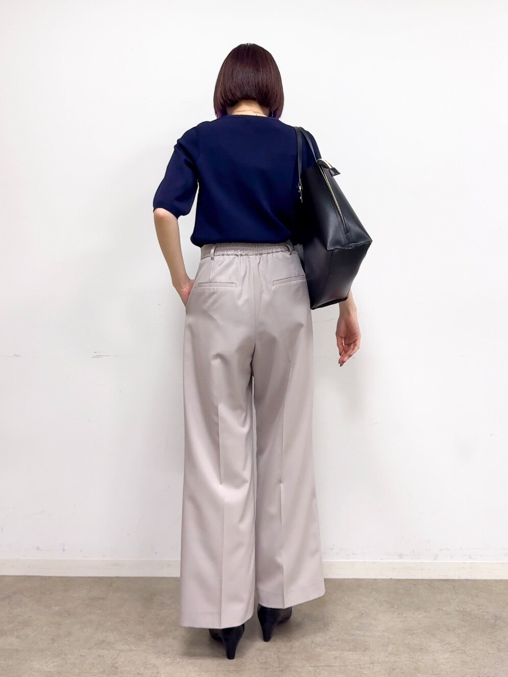 ブルー系のニット/セーター、ベージュ系のその他パンツ、ブラック系のパンプスを着用したレディースの春コーディネートの3枚目の写真